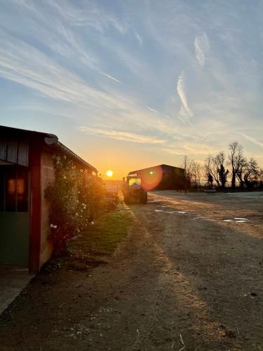 a truck parked next to a building with the sunset at Chambre à la ferme in Précy-le-Sec