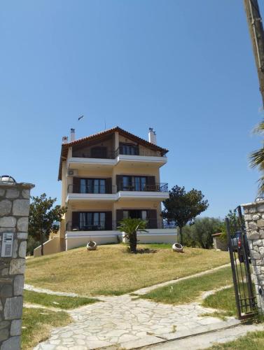 a large building on top of a grassy hill at κτήμα ΝΟΣΤΟΣ in Aígio