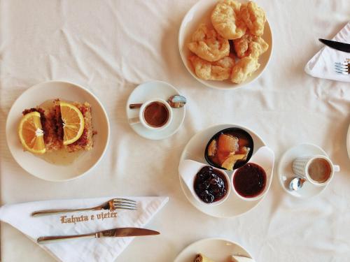 a table with plates of food and cups of coffee at Lahuta e Vjeter Agroturizem in Laç