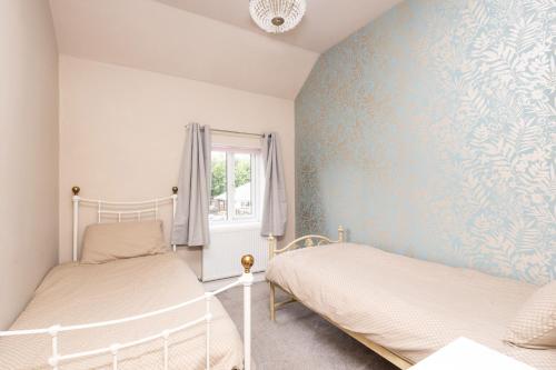 ein Schlafzimmer mit 2 Betten und einer blauen Wand in der Unterkunft Canal Side Cottage Wakefield in Stanley