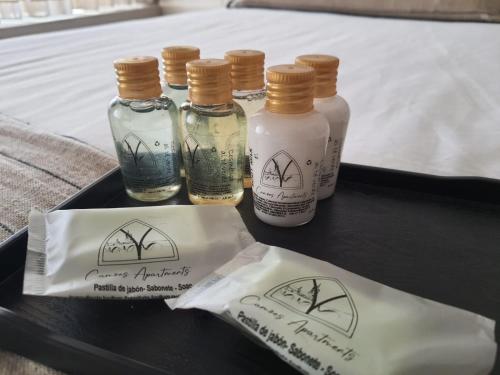 four bottles of essential oils on a tray on a bed at Camões Apartments in Ponte de Lima
