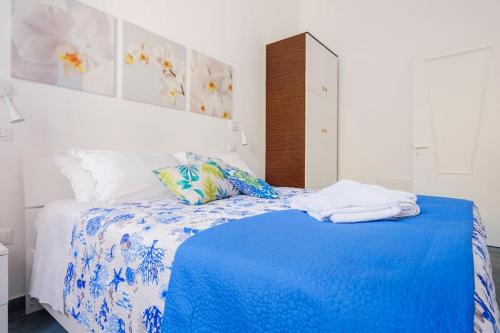 - une chambre avec un lit bleu et blanc et des serviettes dans l'établissement La Casa degli Oleandri, à Torre Santa Sabina