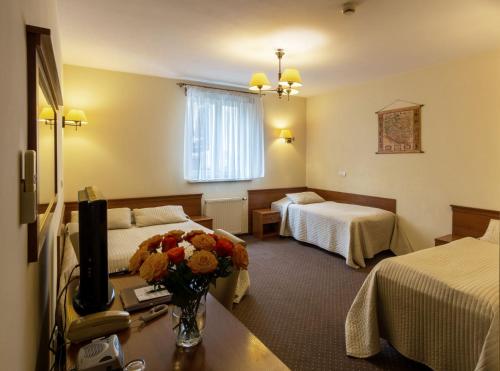 una camera d'albergo con due letti e una televisione di U Pana Cogito a Cracovia