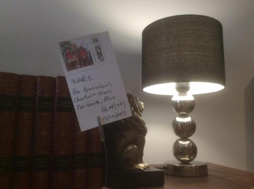 a lamp with a sign on it next to books at Chambres et Table d'hôtes La Belle Lensoise in Lens
