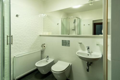 a white bathroom with a toilet and a sink at U Pana Cogito in Kraków