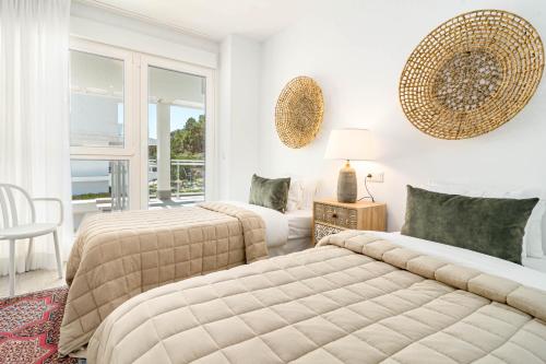 ベナアビスにあるRIB2A- Relaxed & modern flat in Benahavisのソファとテーブル付きの客室内のベッド2台