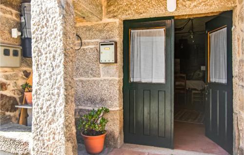 une porte verte dans un bâtiment en pierre avec une plante dans l'établissement Amazing Home In A Peroxa With House A Panoramic View, 