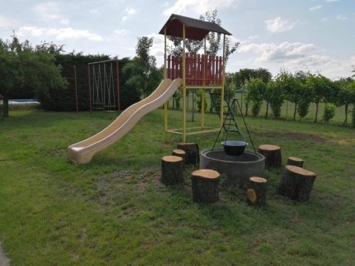 a playground with a slide and some logs at HutiFeri apartman in Siófok