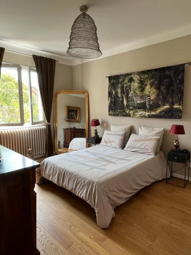 une chambre avec un grand lit et un tableau au mur dans l'établissement Maison de charme avec jardin, à Carcassonne