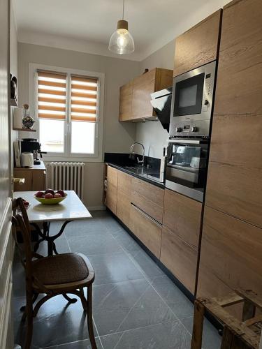 une petite cuisine avec une table et un micro-ondes dans l'établissement Maison de charme avec jardin, à Carcassonne