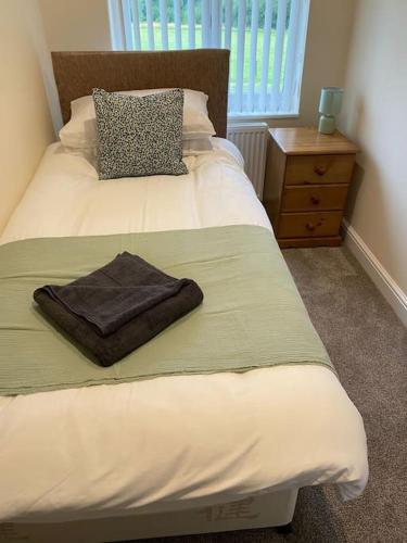 a bed with a brown towel on it in a bedroom at Beautiful mid wales cottage in Garth