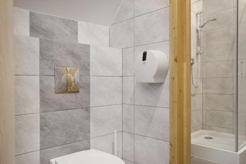 uma casa de banho com um WC branco e um chuveiro em Agroturystyka Wilcza Wola 