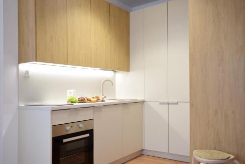 uma cozinha com armários brancos e um lavatório em Agroturystyka Wilcza Wola 