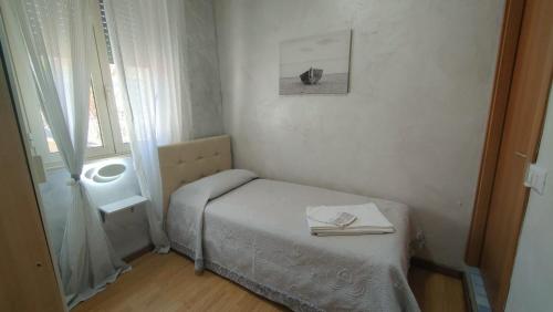 ein kleines Schlafzimmer mit einem Bett und einem Fenster in der Unterkunft Hotel Eriale in Rimini