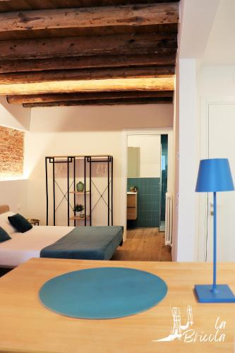a bedroom with two beds and a blue lamp on a table at La Bricola - Sirocco e Garbin in Chioggia