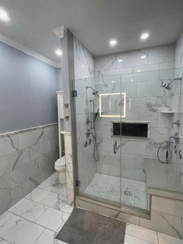 a bathroom with a glass shower with a toilet at Riverside Retreat Waterfront Guest House in Groton