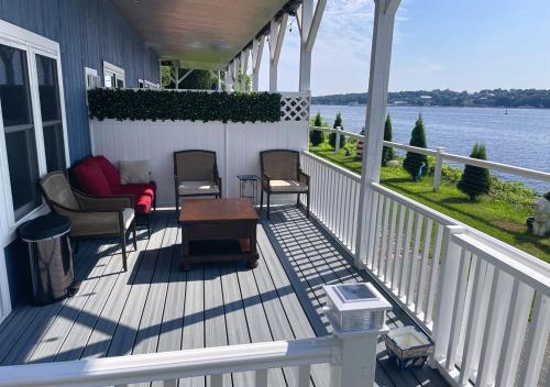 a porch with chairs and a table on a house at Riverside Retreat Waterfront Guest House in Groton