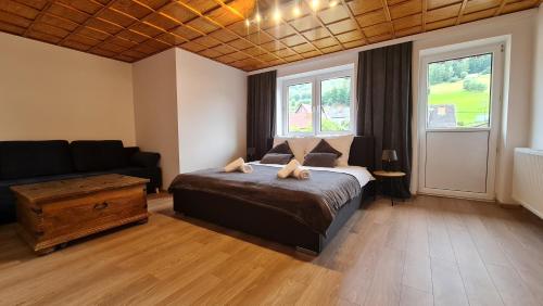 um quarto com uma cama e um sofá em Szumią Płaziny em Muszyna