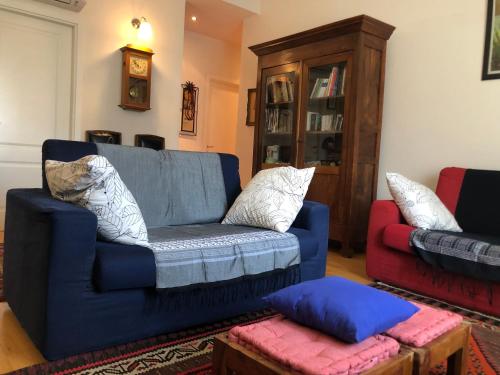 un soggiorno con divano blu e sedia rossa di Appartamento casa sul fiume a Parma