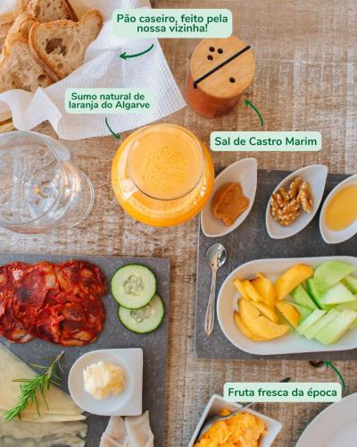 a table topped with different types of food on plates at Monte Do Malhao - Art, Eco & Spa in Castro Marim