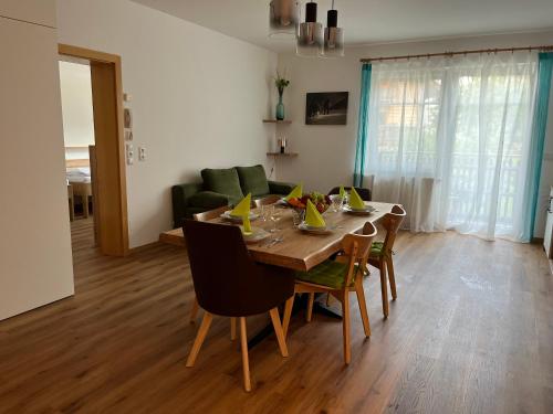 a dining room table and chairs in a living room at Appartement NaMoll in Ausserfragant