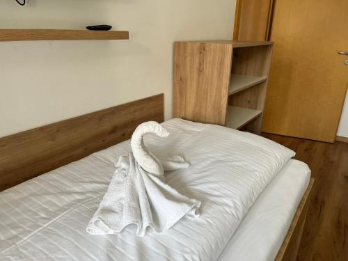 a white bed with a towel on top of it at Appartement NaMoll in Ausserfragant