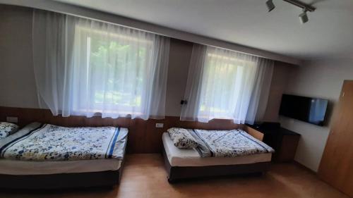 a bedroom with two beds and a window with curtains at Ośrodek Wypoczynkowy Graniczny in Zwardoń