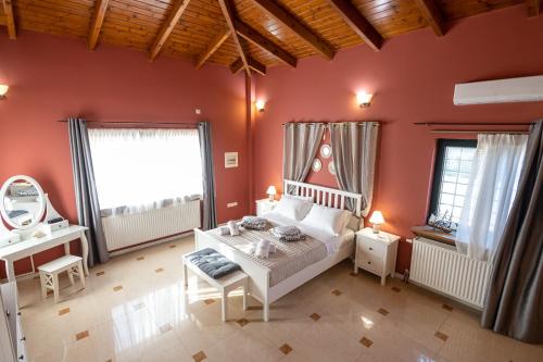 1 dormitorio con paredes rojas, 1 cama y espejo en REALE - Art Luxury Villa, en Mitikas