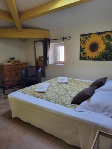 a bedroom with a large bed with a table at Les parfums du midi in Saint-Victor-de-Malcap