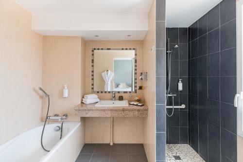 a bathroom with a tub and a sink and a shower at Le Place Neuve in Brullioles