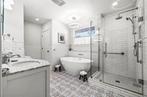 a white bathroom with a tub and a shower at The Kenwood Gables in St Petersburg