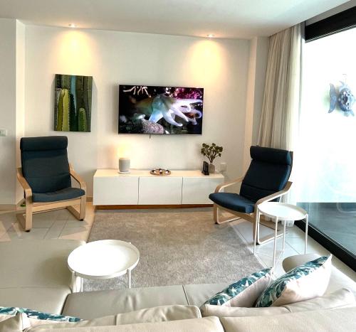 een woonkamer met een bank en twee stoelen bij Casa Las Olas in Palm-mar