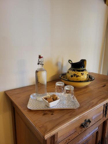 a wooden table with a bottle and glasses on it at Les parfums du midi in Saint-Victor-de-Malcap