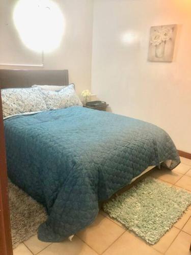 Nazareth的住宿－Catherine's Retreat，一间卧室配有一张带蓝色毯子和地毯的床。