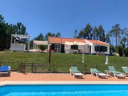 a villa with a swimming pool and a house at Villa Monte dos Pinheiros in Grândola