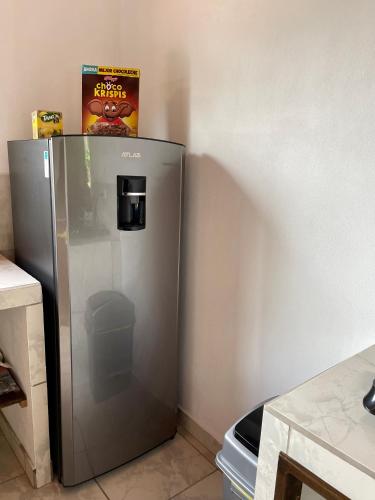 a stainless steel refrigerator in a corner of a kitchen at Casa Paraiso Tropical in Parrita