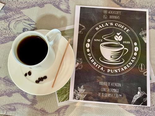 a cup of coffee sitting on a table next to a book at Casa Paraiso Tropical in Parrita