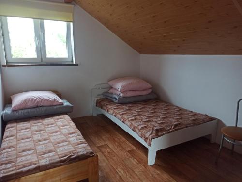 ein kleines Zimmer mit 2 Betten und einem Fenster in der Unterkunft Zielony Domek in Polańczyk