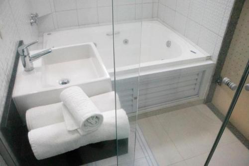 a bathroom with a shower and a sink and a tub at Polar Rio Hotel in Sao Paulo