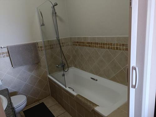 a bathroom with a shower with a tub and a toilet at Ocean View Villas F16 Port Edward in Port Edward