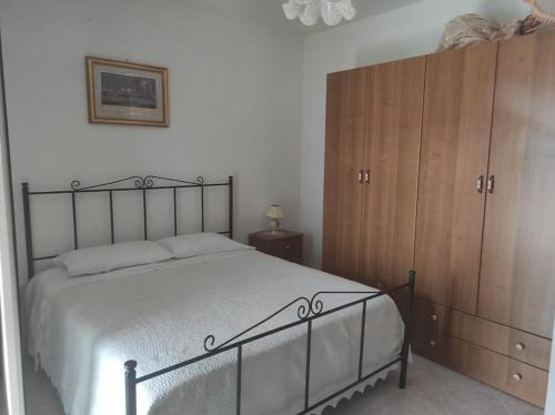 - une chambre avec un grand lit et des placards en bois dans l'établissement Casa Vacanze Le Vigne, à Rionero Sannitico