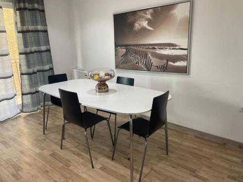 a white table and chairs in a room with a painting at Amplio apartamento en Crevillente in Crevillente