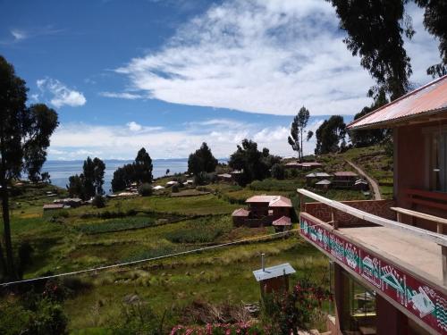 einen Blick auf einen Bauernhof vom Balkon eines Hauses in der Unterkunft Taquile Sumaq Wasi - Casa de Felipe e Ines in Huillanopampa