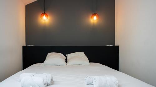 a bedroom with a bed with two white pillows at La Capitale - Les Gîtes de L Argile in Barcelonnette