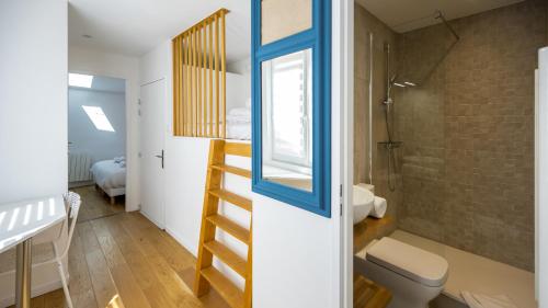 a bathroom with a toilet and a shower and a staircase at La Capitale - Les Gîtes de L Argile in Barcelonnette