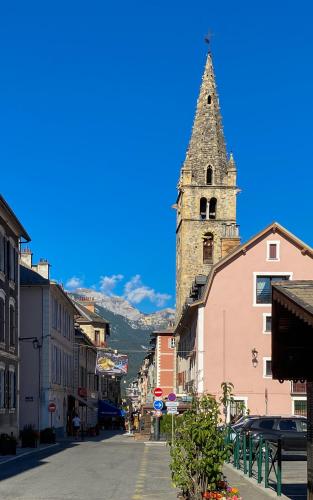 a city street with a clock tower in the distance at La Capitale - Les Gîtes de L Argile in Barcelonnette
