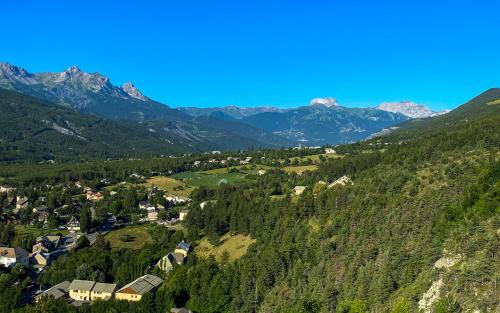 a village in a valley with mountains in the background at La Capitale - Les Gîtes de L Argile in Barcelonnette