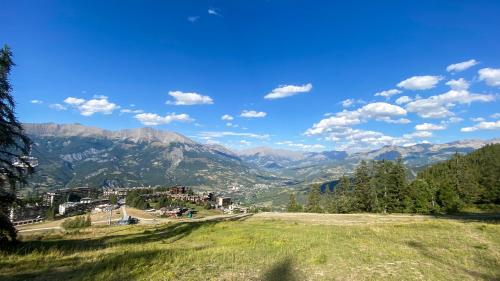a view of the mountains from a grassy hill at La Capitale - Les Gîtes de L Argile in Barcelonnette