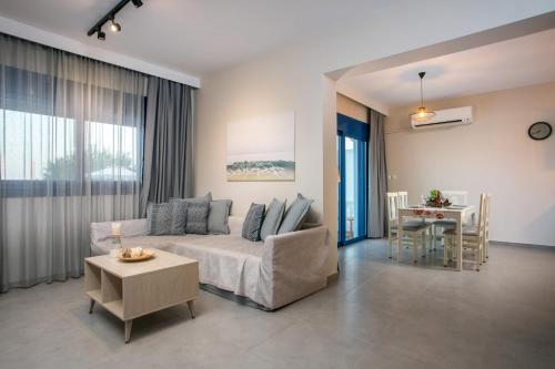 een woonkamer met een bank en een tafel bij RITA MARE seafront villas in Gennadi