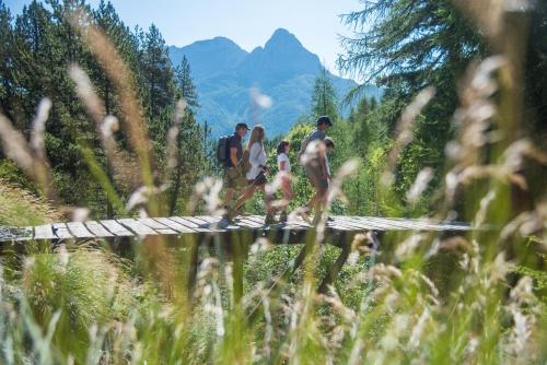 a group of people crossing a bridge over a river at La Capitale - Les Gîtes de L Argile in Barcelonnette